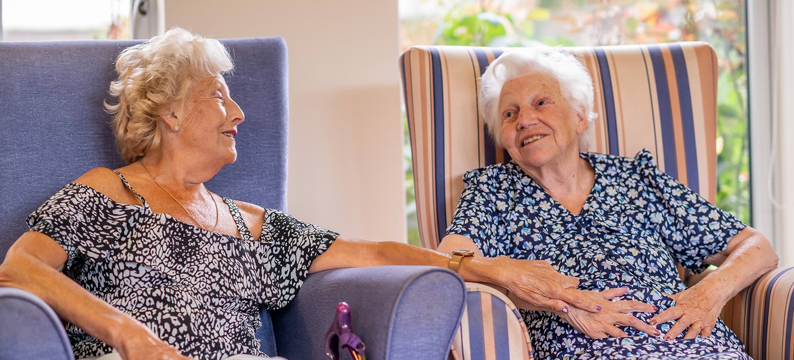 Two ladies chatting in armchairs