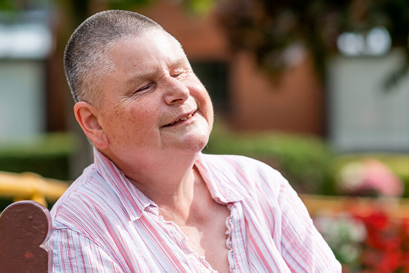 Image of Kate sat on a bench enjoying the sun