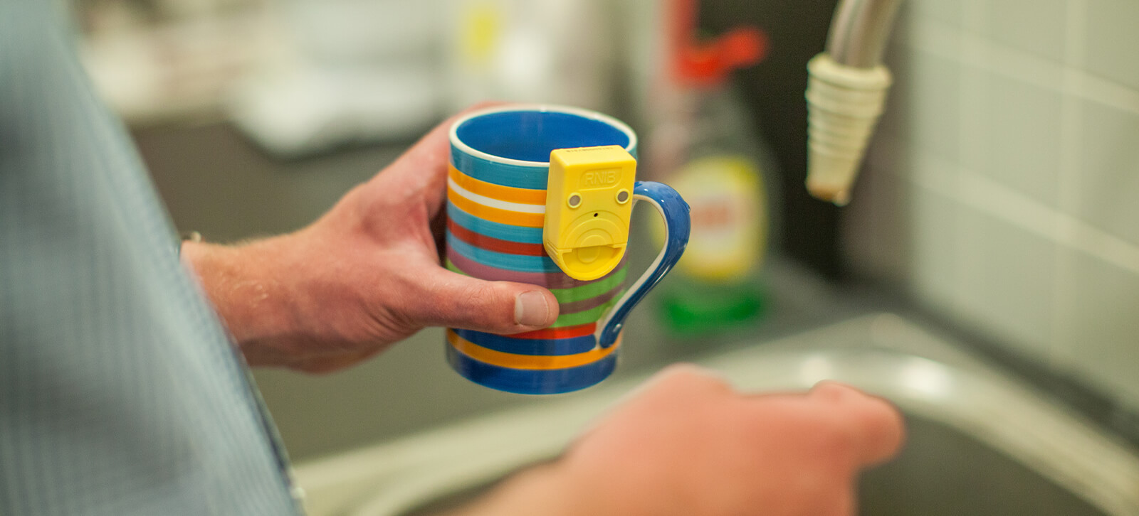 Someone holding a mug with a sensor on the side