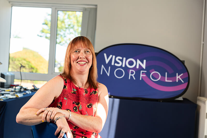 Penny in front of Vision Norfolk Logo