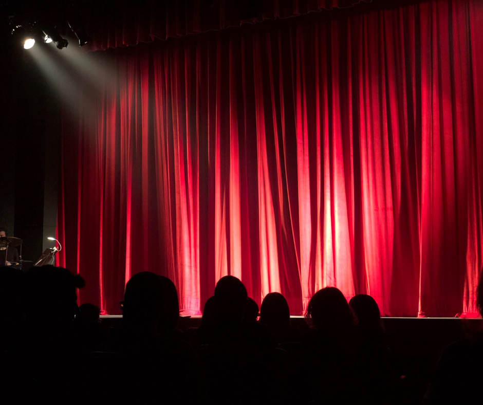 Theatre stage with closed curtains and an outline of an audience