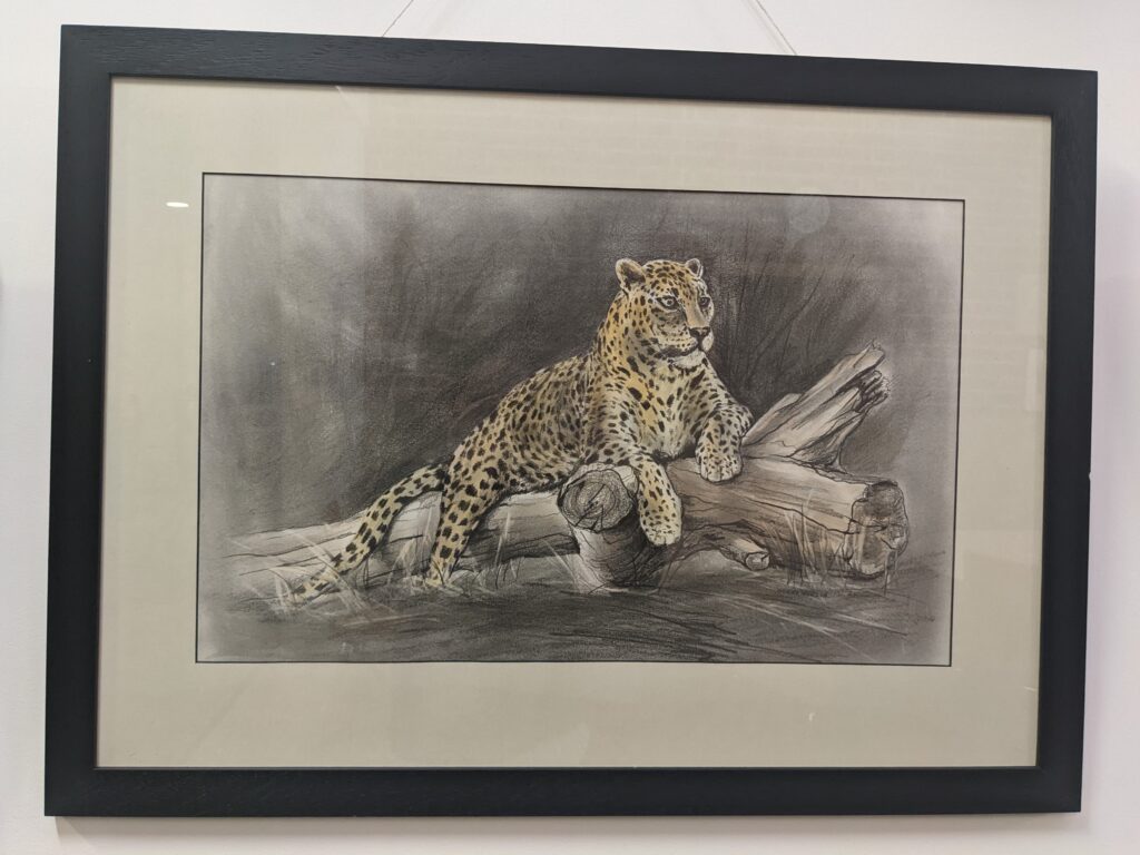 Painting of leopard lying on a log.