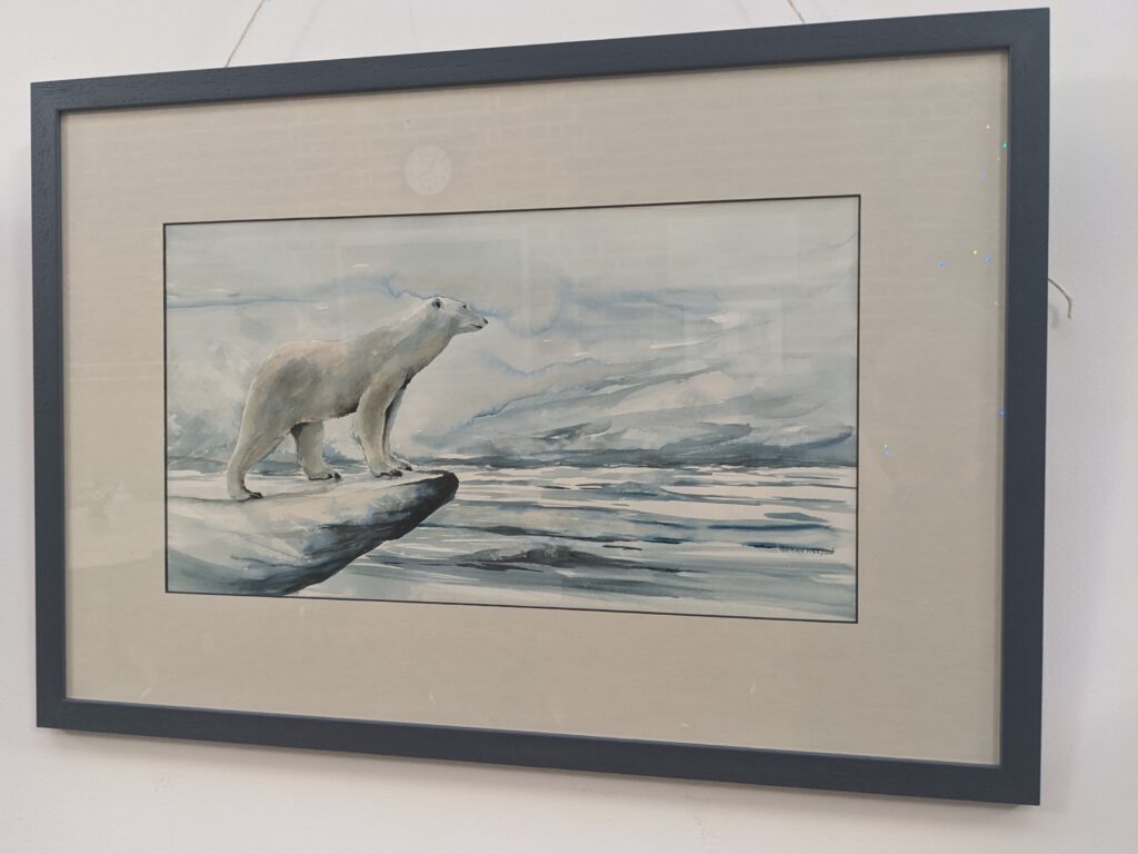 Artwork featuring a polar bear over looking an arctic ocean scene