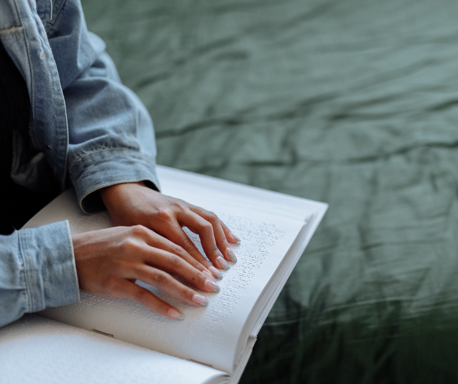 Two hands reading a braille book