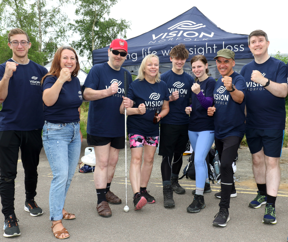 A group of people in Vision Norfolk shirts showing off their muscles to the camera