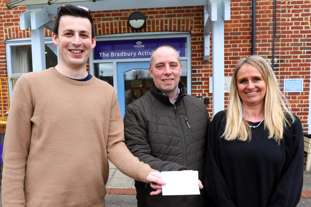 Paul Debenham (centre) presents a cheque for £1,000 to Josh Bartholomew and Barbara Dunn of Vision Norfolk