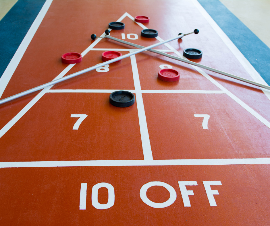 Shuffleboard sticks and pucks lying on a board.