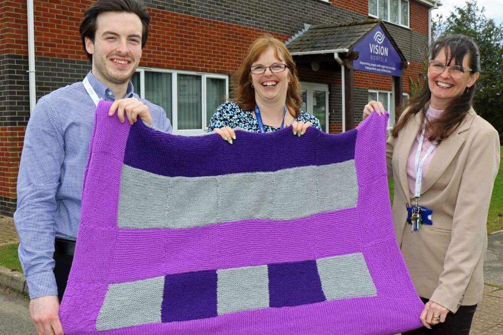 Zoe Tinkler of Vison Norfolk (centre) presents one of the blankets to Kieran Gamble and Dawnmarie Bird of The Purfleet Trust