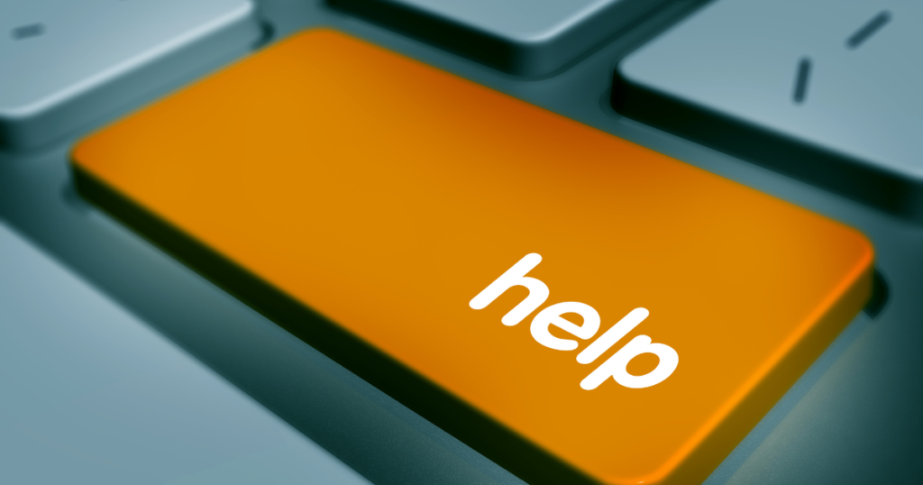 Large orange key on a computer keyboard with the word "help" on it.