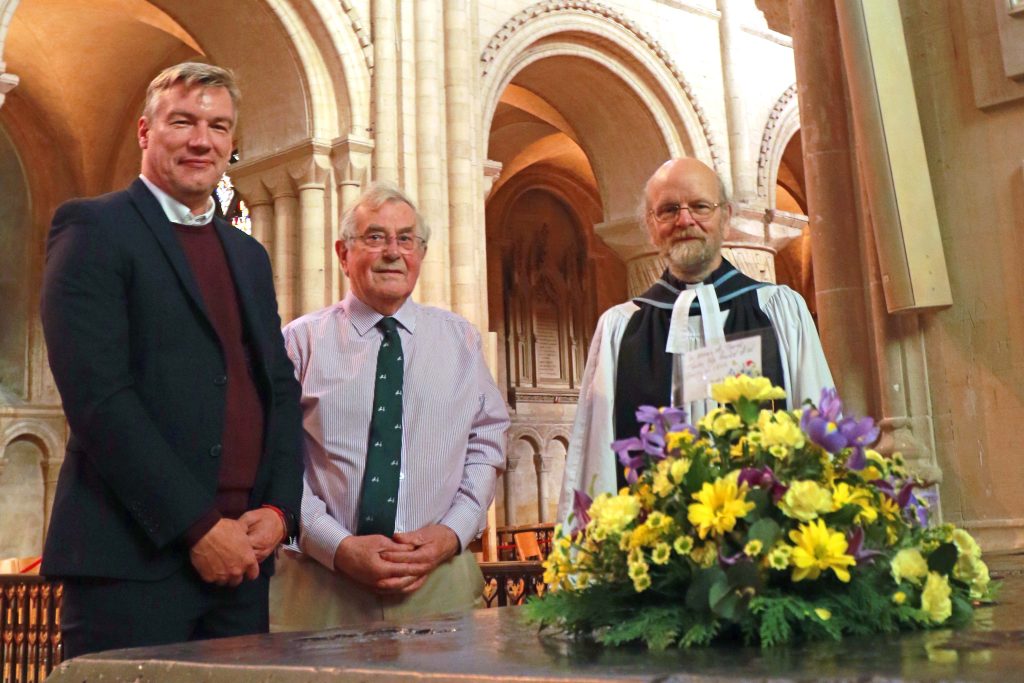 Andrew Morter, Peter Spaul and Canon Andy Bryant lay flowers at the memorial to Thomas Tawell in Norwich Cathedral