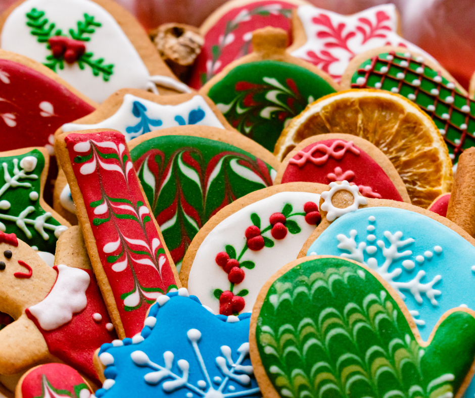 Close up of a pile of winter holiday themed biscuits including, snowflakes, candy canes, mittens, gingerbread people and baubles.