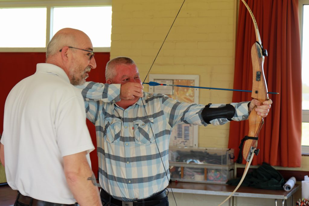 Vision impaired archer Jason Beasley is guided by Archery GB coach Andy Beer