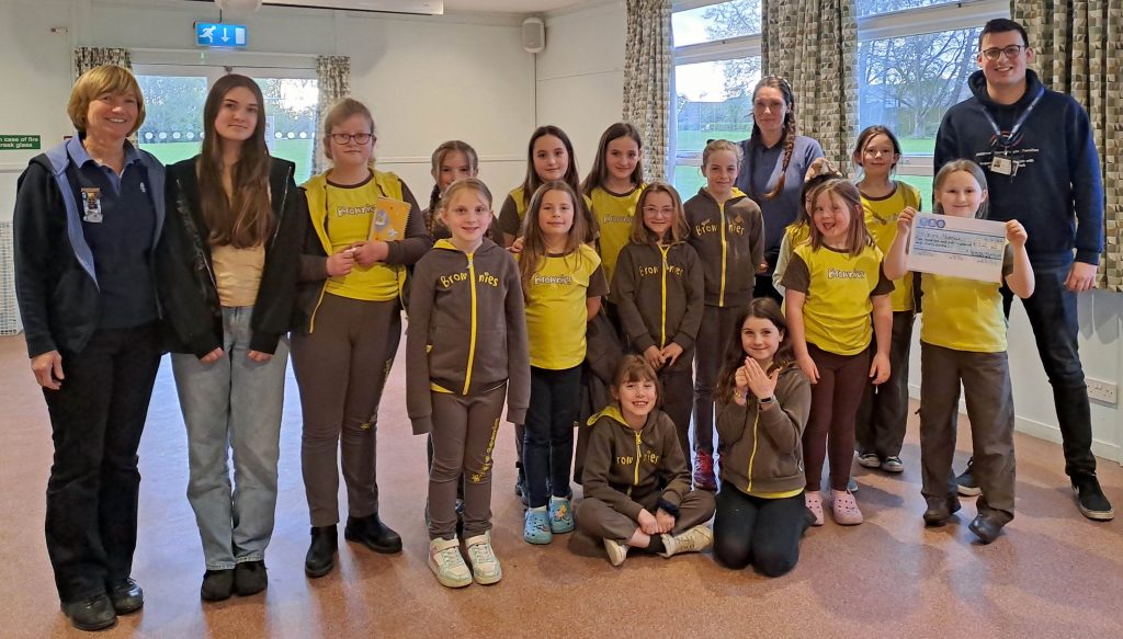 Josh Bartholomew of Vision Norfolk (right) receives the cheque from 1st Corpusty and Saxthorpe Brownies