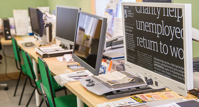A row of desks and computer screens.