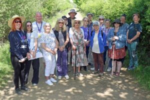 A group of vision impaired nature lovers from west Norfolk were taken on a special sensory tour of Wild Ken Hill to celebrate the launch of a new video celebrating how people living with sight loss can enjoy nature. The film – a collaboration between filmmaker Pete Naylor, curator and programmer Ruth Dillon, Norfolk sight loss charity Vision Norfolk and community walking network organisation Slow Ways – features Gill, who has been blind since a car accident in her teens. With a guide, she is able to enjoy the hugely varied wildlife and habitats that make up Wild Ken Hill near Heacham. To celebrate the making of the video, the vision impaired group toured the project, enjoying the sounds and smells as well as the sights of the plants, birds and wildlife which reside there. Expert guide Carl Chapman was on hand to help with species identification and give an insight into the conservation and rewilding work taking place at Wild Ken Hill. The film’s producer Ruth Dillon said, “We hope the piece inspires and encourages as many people as possible to come out and walk in the landscape. Building community and offering unique experiences in nature is key to the work of Wild Ken Hill. “In the film, we join Gill on a walk with a companion. It’s late summer, the air is warm, you can feel the sun on your skin and the smells and colours of the season are appearing all around us. “As we accompany them on their walk, we begin to understand a little more what it’s like to journey through a landscape with our focus on our other senses. Our route journeys through woodlands, wetlands and coastal habitats. “The descriptions of what they are hearing, experiencing and feeling while on their walk tell a deeply personal story of what walking through countryside and connecting to the natural world means to them.” Vision Norfolk west Norfolk hub co-ordinator Penny Whitby, who is blind herself, joined the group on the special guided tour, and said, “Wild Ken Hill is a magical place, and this project has demonstrated that people living with sight loss can explore and enjoy the nature and wildlife which thrive here. “We were delighted to be asked to take part in the project and support the production of the film, and we hope very much that it encourages vision impaired people to come together, walk and enjoy nature more often.” The film can be viewed online at https://buildstories.slowways.org/how-does-it-feel-to-walk-blind. • Wild Ken Hill is a family-run farm in coastal West Norfolk comprising areas of regenerative farming, rewilding and traditional conservation. Its mission is to fight climate change, restore nature, and provide benefits to the local community. Engagement and education are at the heart of what they do. This is delivered through a programme of events, tours, schools visits, volunteering opportunities and open days.