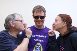 Collegaues Karl Ablitt (left) and Catherine Bond help Ed Bates keep quiet ahead of his sponsored silence