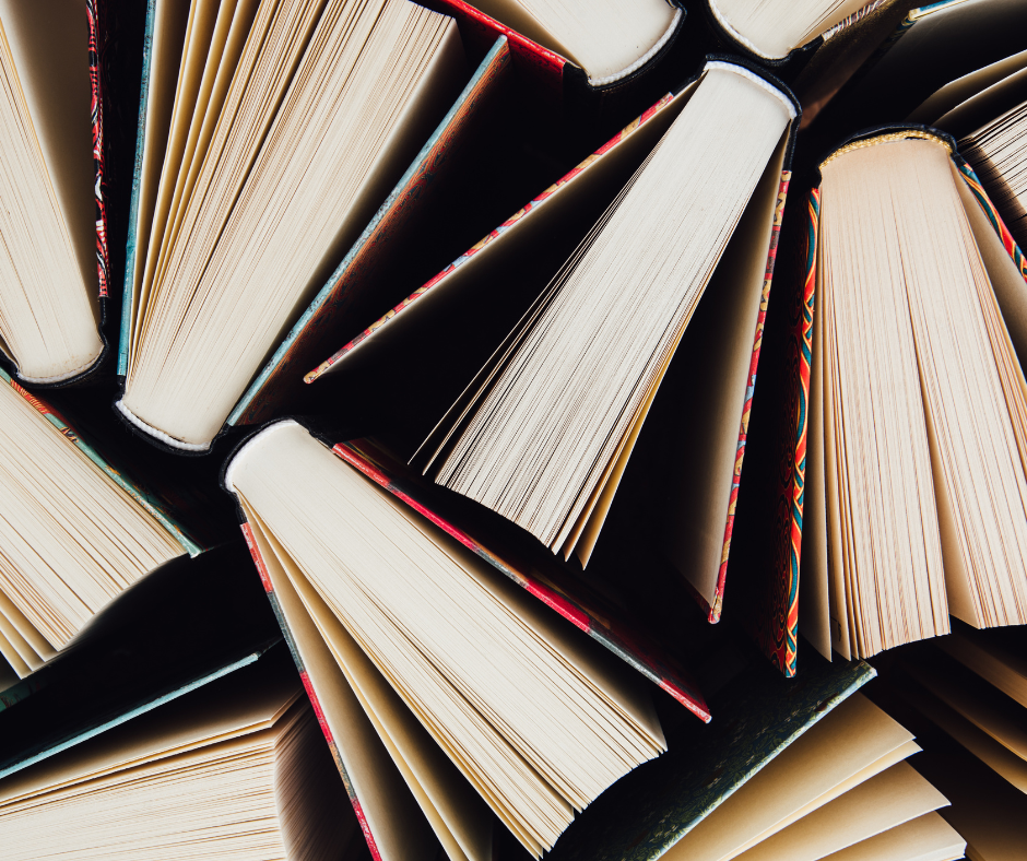 The spines and pages of slightly opened books photographed from above.