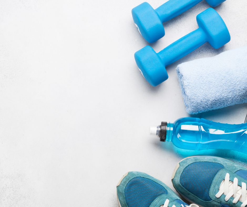 Blue exercise equipment including trainers, a water bottle, a towels and weights, on a white background.