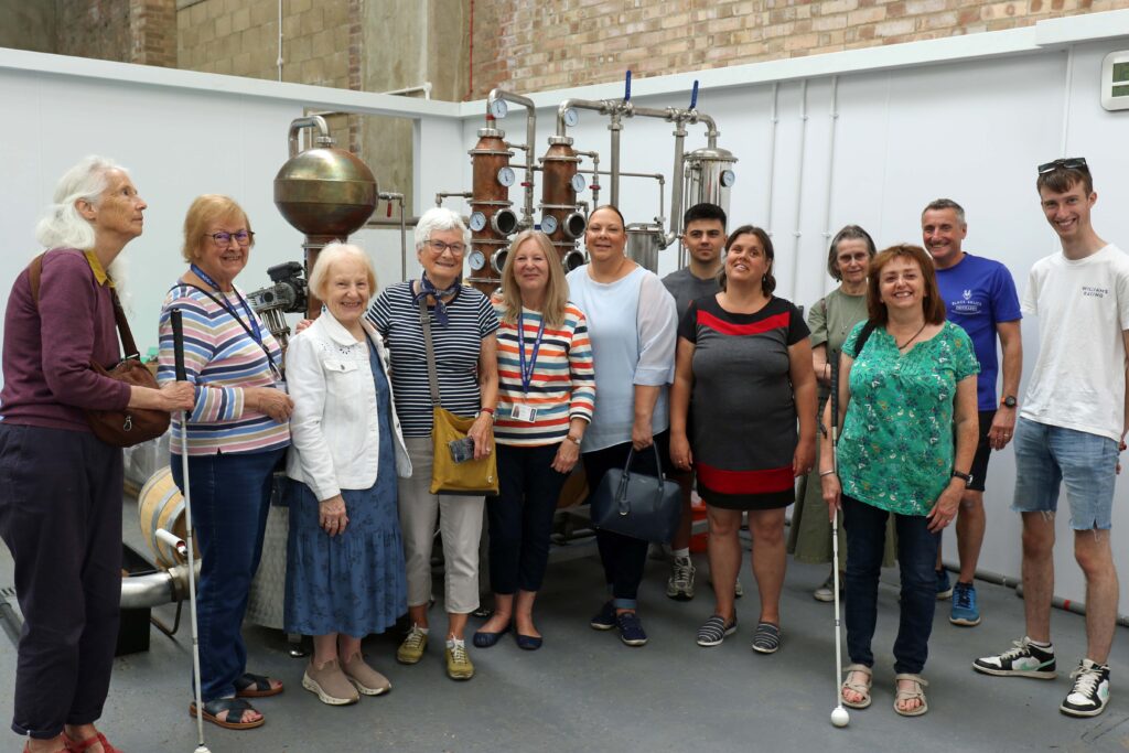 The group of vision impaired visitors in the still room at Black Shuck Distillery