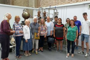 The group of vision impaired visitors in the still room at Black Shuck Distillery