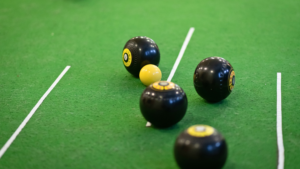 Bowls balls in play on a green carpet.