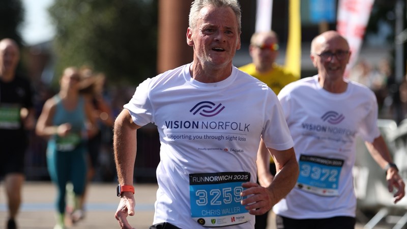 Chris running in Run Norwich 2025 wearing a Vision Norfolk top.