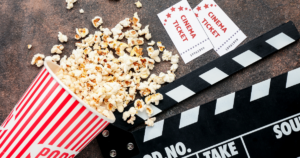 Popcorn, a movie clapper and two cinema tickets.